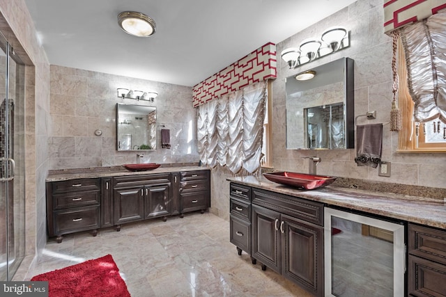 bathroom with a sink, wine cooler, two vanities, and tile walls