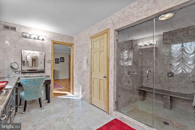 bathroom featuring marble finish floor, a shower stall, visible vents, and crown molding