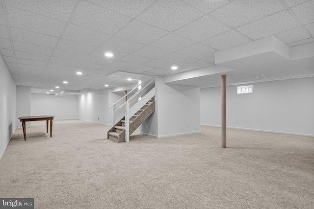 finished below grade area featuring recessed lighting, stairs, baseboards, and light colored carpet