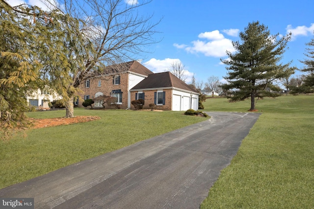 view of front of house with a garage, a front yard, and brick siding