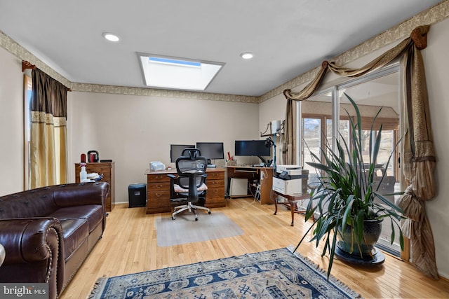 office space with a skylight, light wood finished floors, and recessed lighting