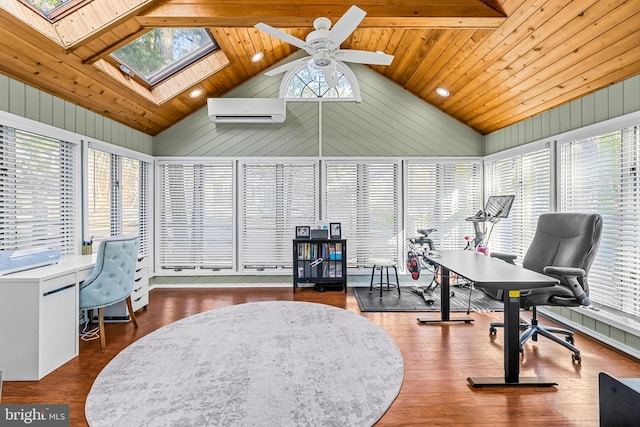 office featuring plenty of natural light, vaulted ceiling with skylight, an AC wall unit, and wood finished floors