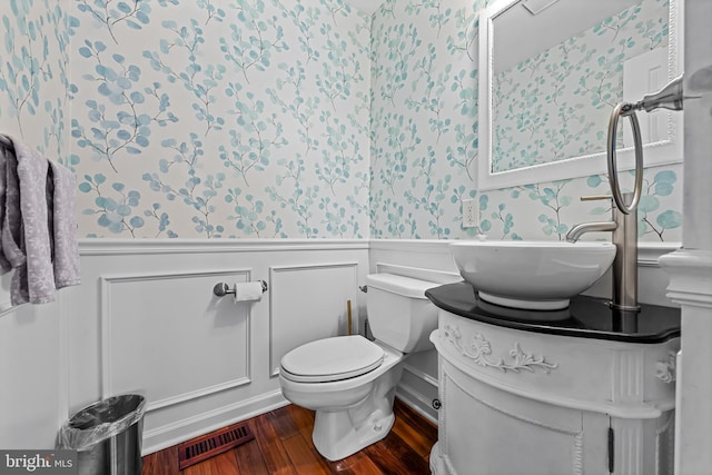 bathroom with visible vents, wainscoting, toilet, wood finished floors, and vanity