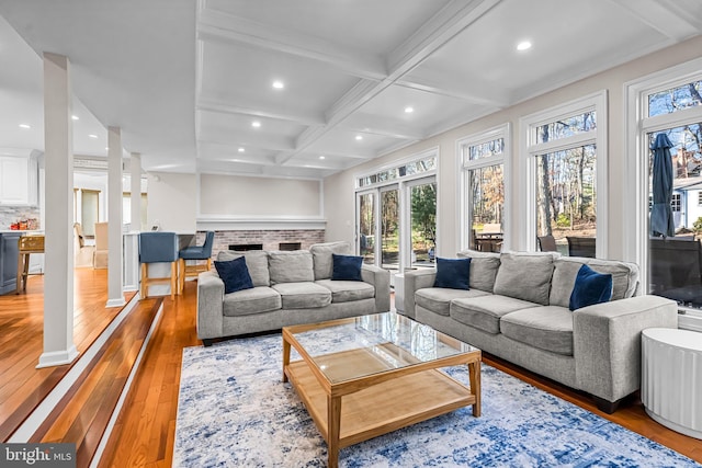 living area with recessed lighting, coffered ceiling, light wood-style floors, a brick fireplace, and beam ceiling