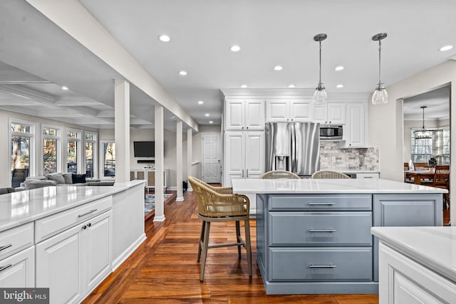 kitchen with appliances with stainless steel finishes, light countertops, white cabinetry, and tasteful backsplash