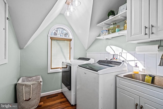 washroom with cabinet space, visible vents, dark wood-style flooring, washing machine and clothes dryer, and a sink