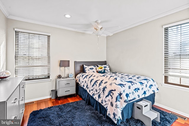 bedroom featuring multiple windows, crown molding, baseboards, and wood finished floors