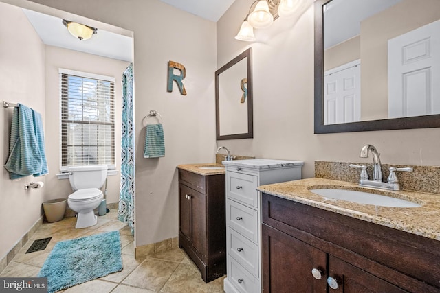 full bathroom featuring two vanities, a sink, visible vents, and baseboards