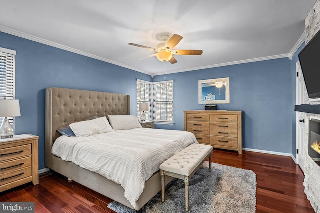 bedroom with a warm lit fireplace, baseboards, wood finished floors, and crown molding