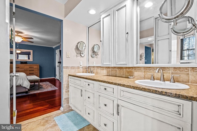 full bathroom with crown molding, a ceiling fan, a sink, and tile patterned floors