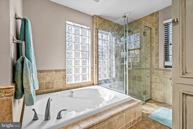 bathroom featuring a stall shower, a garden tub, and tile patterned floors