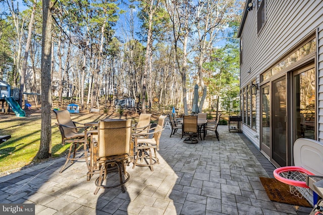 view of patio / terrace with a playground and outdoor dining space