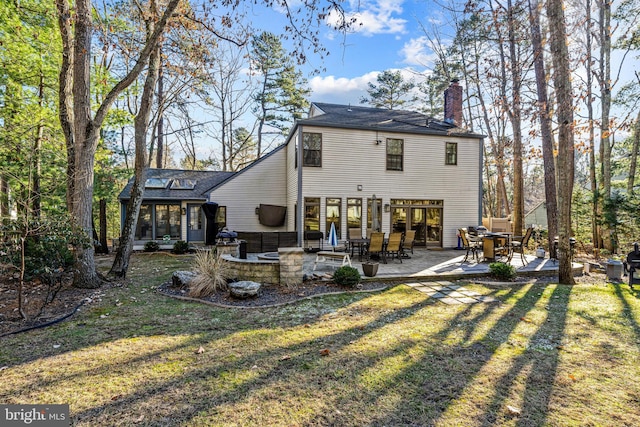 back of house with a yard, a chimney, and a patio area