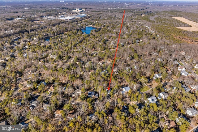 birds eye view of property featuring a forest view and a water view