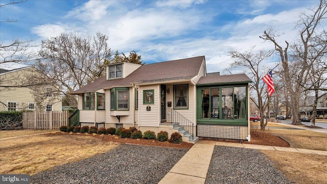 view of front of house featuring a sunroom and fence