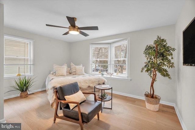 bedroom featuring baseboards, ceiling fan, and light wood-style floors