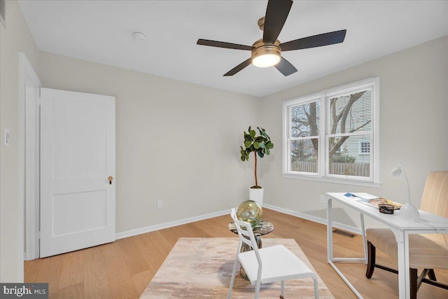 office space featuring light wood finished floors, visible vents, and baseboards