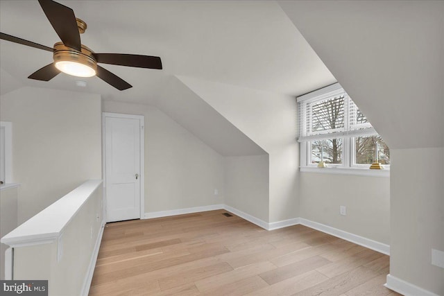 additional living space with lofted ceiling, light wood-type flooring, and baseboards