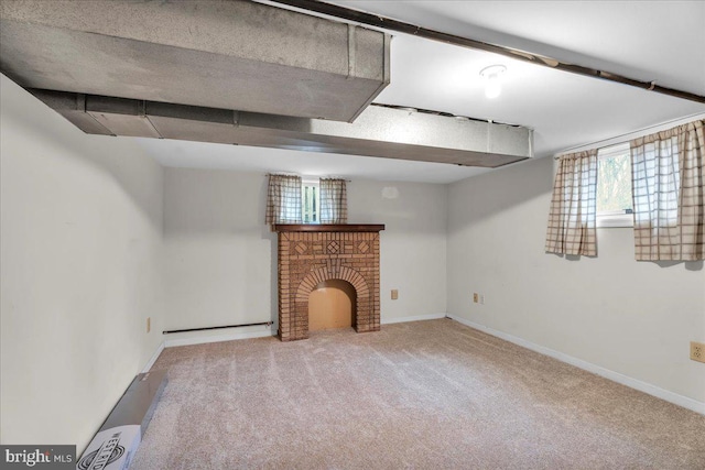 below grade area with a brick fireplace, carpet, and baseboards