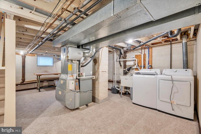 basement with washing machine and dryer, carpet, a sink, and heating unit