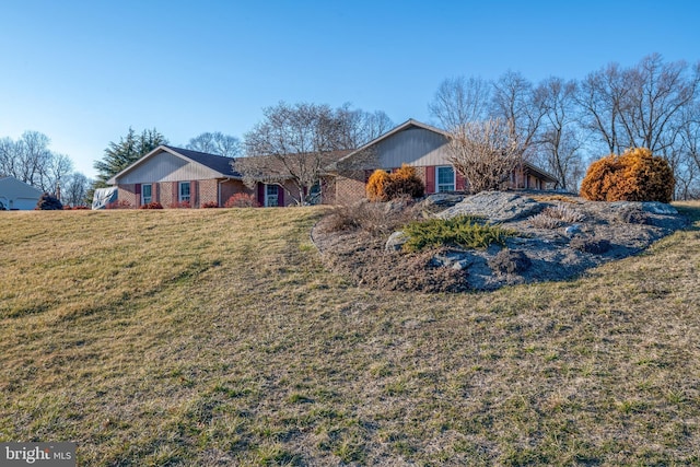 ranch-style home with brick siding and a front yard