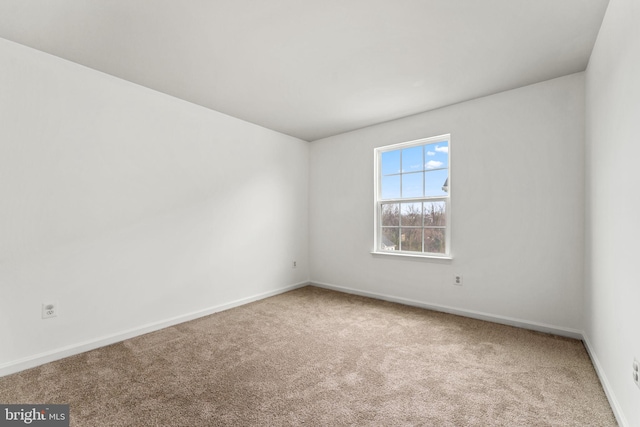 carpeted empty room featuring baseboards