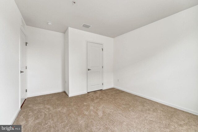 unfurnished bedroom featuring baseboards, visible vents, and carpet