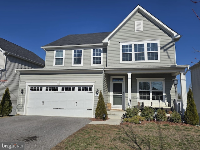 traditional-style house featuring aphalt driveway, a porch, and an attached garage