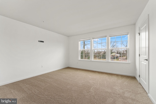 spare room featuring baseboards and carpet