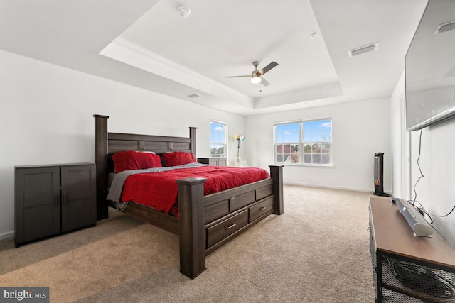 bedroom with a tray ceiling, baseboards, visible vents, and carpet floors