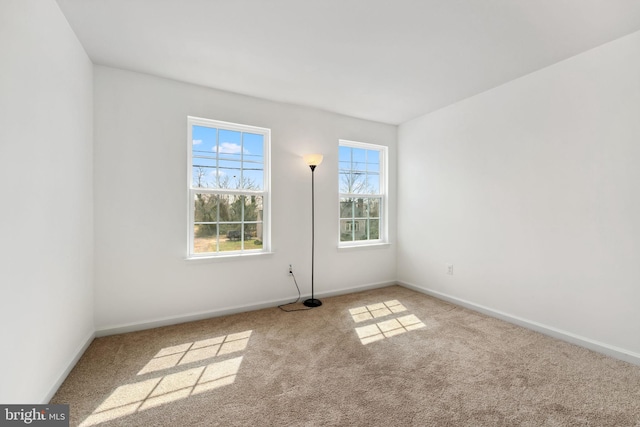 carpeted empty room with baseboards