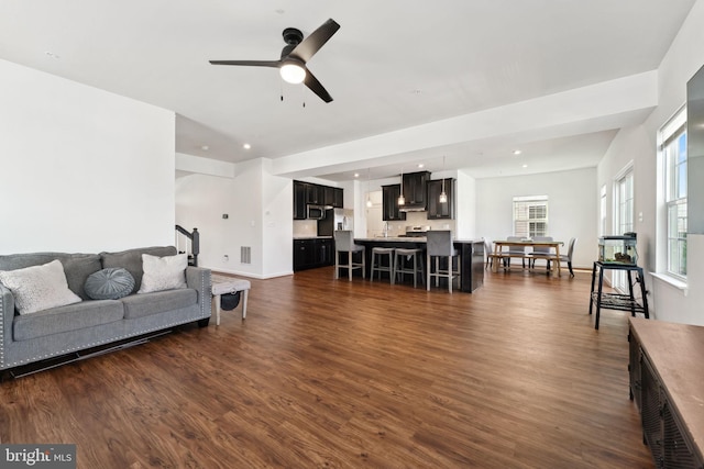 living area with baseboards, ceiling fan, recessed lighting, and dark wood-style flooring