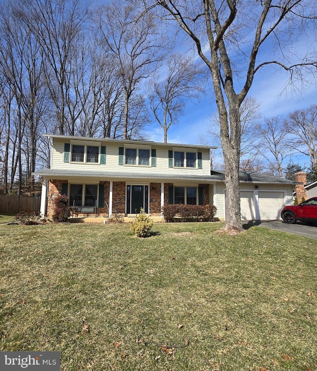 view of front of home with aphalt driveway, a front yard, brick siding, and an attached garage