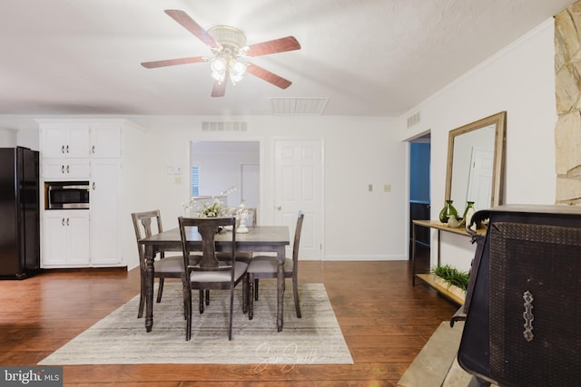 dining area featuring dark wood-style flooring, visible vents, baseboards, ceiling fan, and ornamental molding