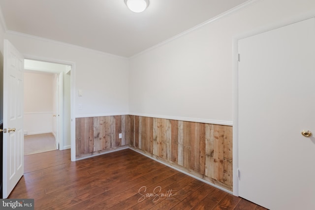 unfurnished room featuring wooden walls, crown molding, and wood-type flooring