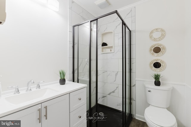 bathroom with toilet, vanity, a stall shower, and visible vents