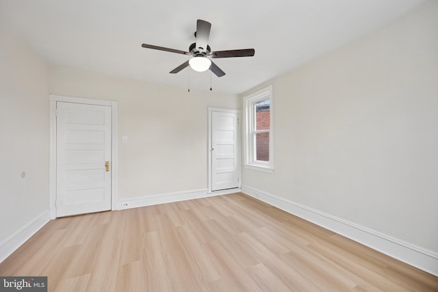 empty room with light wood-style flooring, baseboards, and a ceiling fan