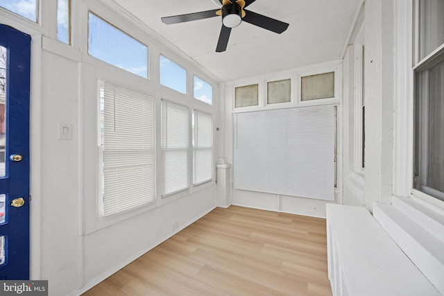 unfurnished sunroom with a ceiling fan