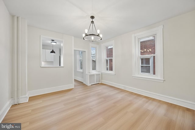 unfurnished dining area featuring light wood-style floors, a healthy amount of sunlight, and baseboards