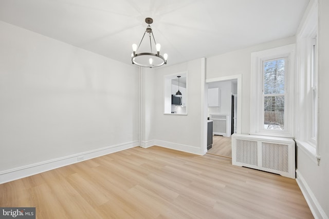 unfurnished dining area with a chandelier, radiator, baseboards, and light wood finished floors