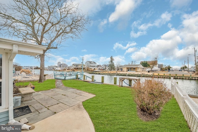 view of yard with a boat dock, a water view, and fence