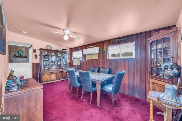 dining space with carpet, wooden walls, a ceiling fan, and a wall mounted air conditioner