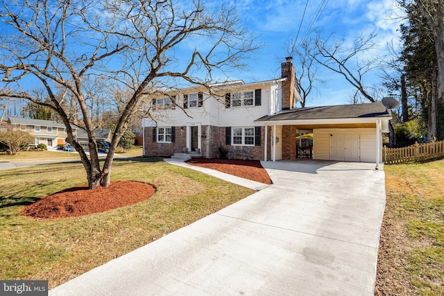 colonial house featuring concrete driveway, a chimney, fence, a front lawn, and a carport