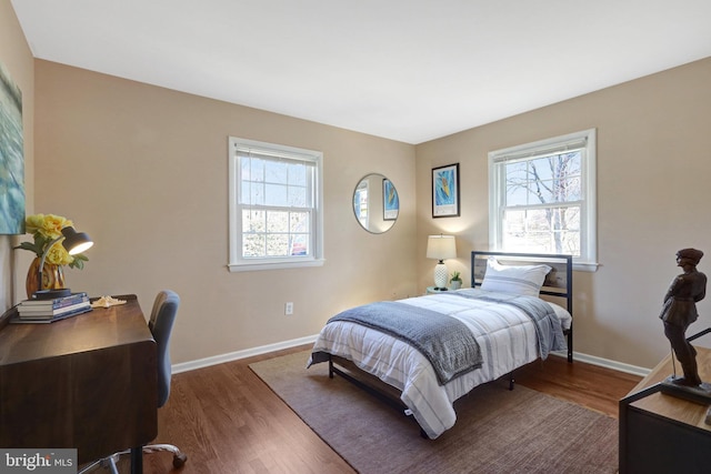 bedroom with baseboards and wood finished floors