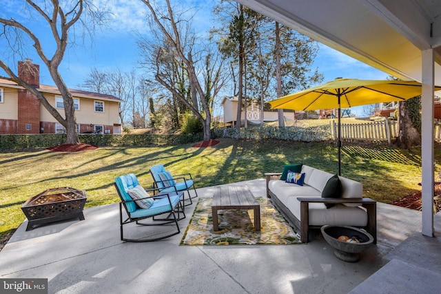 view of patio / terrace with fence and an outdoor living space with a fire pit