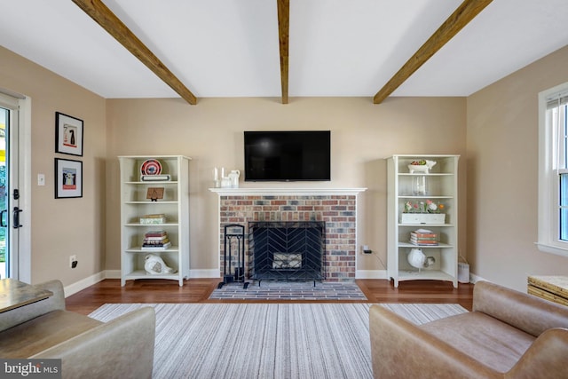 unfurnished living room with a fireplace, wood finished floors, and beam ceiling