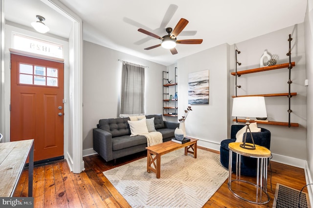 sitting room with hardwood / wood-style floors, a ceiling fan, and baseboards