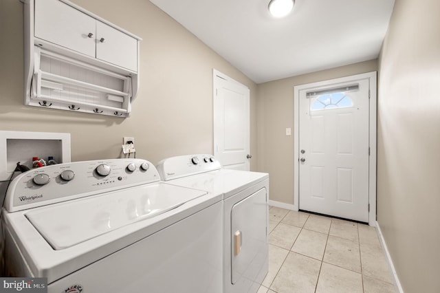 washroom with baseboards, light tile patterned flooring, and washing machine and clothes dryer