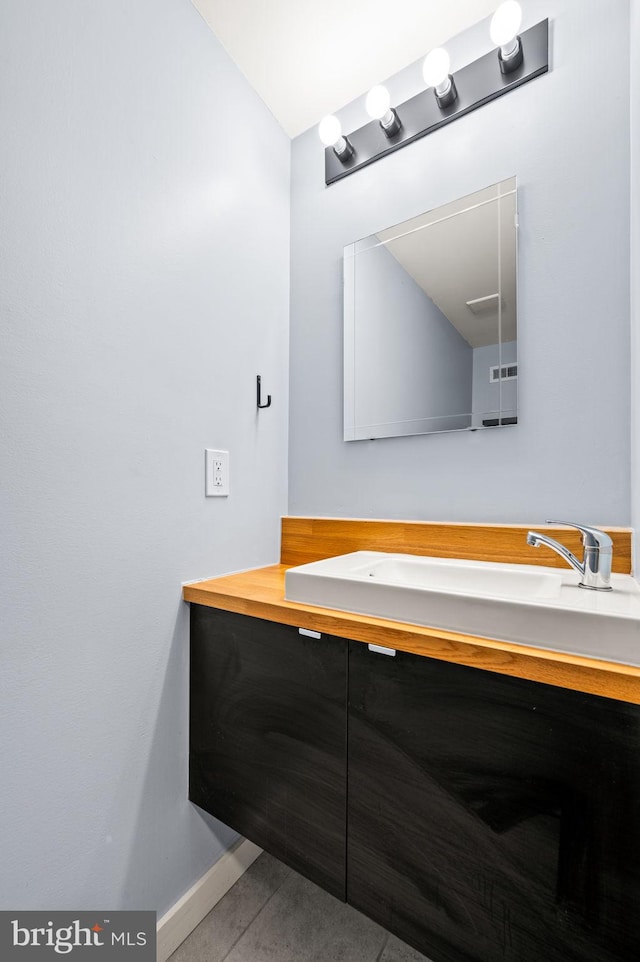 bathroom featuring vanity, tile patterned flooring, visible vents, and baseboards