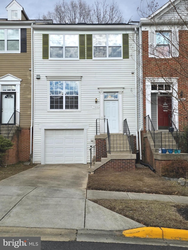 view of property featuring entry steps, concrete driveway, and an attached garage